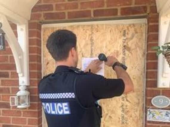 An officer pins the partial closure on the door of the house in Bloxham Vale, Banbury