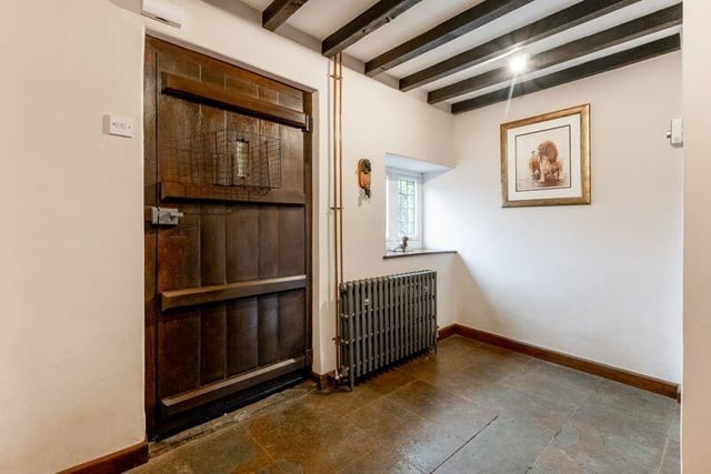 The entrance to the house has a large entrance hallway with stone flooring and an attractive wooden staircase.