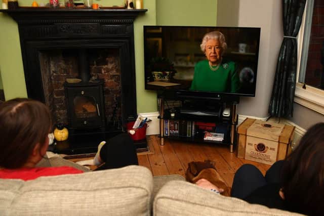 A family watching Britain's Queen Elizabeth II deliver a special address to the UK and Commonwealth recorded at Windsor Castle in relation to the coronavirus outbreak (Photo: PAUL ELLIS/AFP via Getty Images)