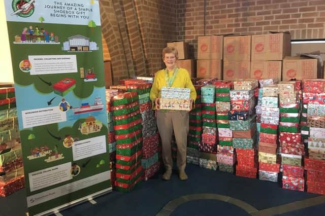Operation Christmas Child organiser Eunice Harradine with a previous years collections of shoeboxes.