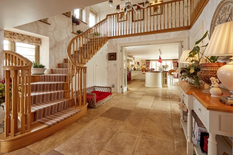 The house features a grand sweeping oak staircase, with an interior balcony overlooking the entrance hall.
