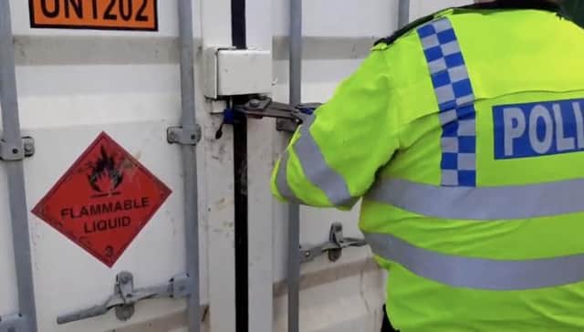 A police officer forces entry on a trailer at the quarry in Finmere