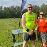 Andy and his guide runner Sharon standing in a field in their running vests