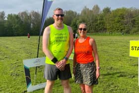 Andy and his guide runner Sharon standing in a field in their running vests