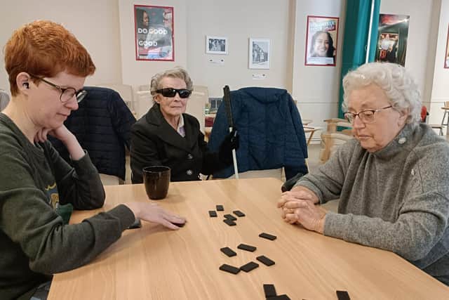 Volunteer Sarah McDonald playing dominoes with Tina and Phyllis.