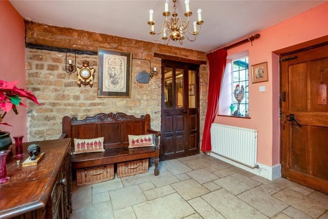 A tiled floor and exposed stone wall entrance welcomes visitors to the property.