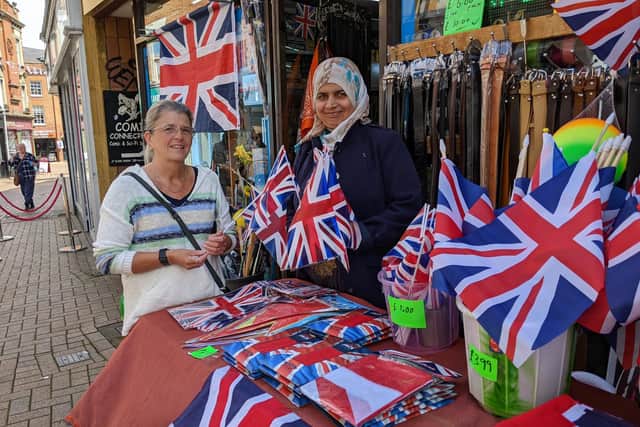 Nighat Bibi sells Jubilee flags to a customer at Bargain Village in Parsons Street, Banbury