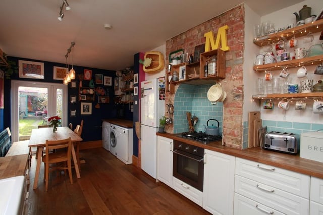 The large kitchen contains a built-in sink and an oven with a four ring gas hob built into the chimney breast.