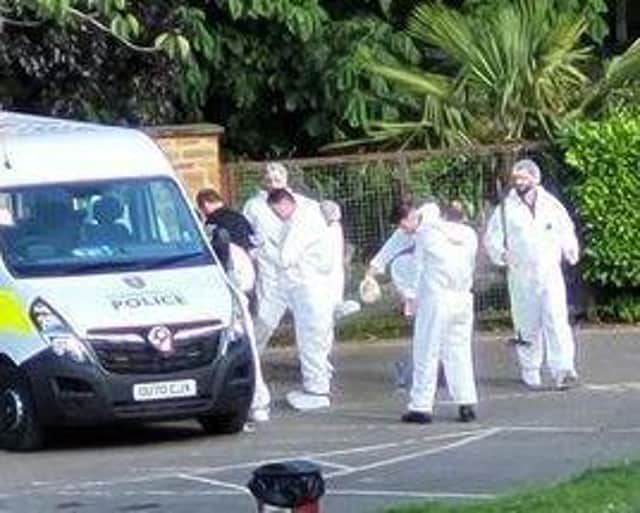 Forensics officers leave People's Park after examining the scene of the stabbing for evidence