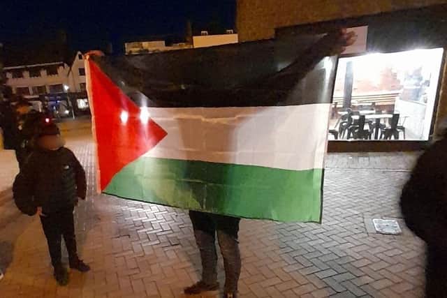 The Palestinian flag is held aloft at the inter-faith peace vigil in Banbury