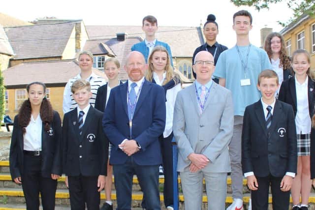 Headteacher Ian Colling is pictured with new head Tom Hollis and pupils from the school