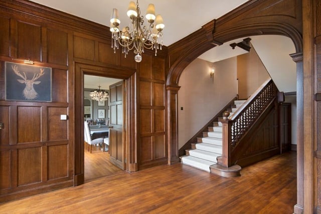 The panelled reception hall provides an impressive entrance to the house with two wings leading off.