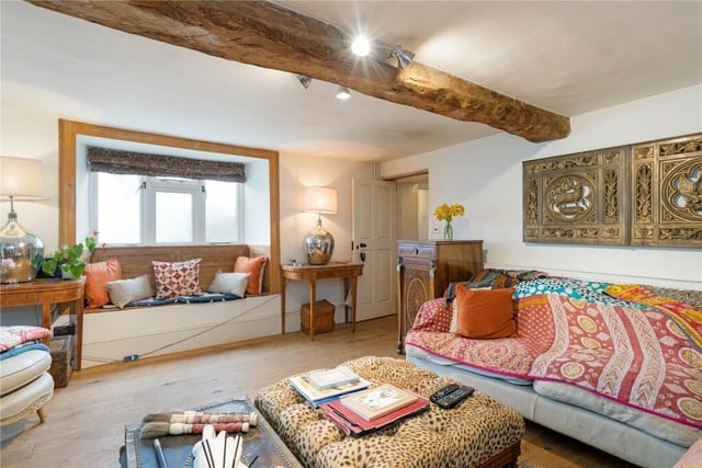The sitting room features exposed beams and a window seat.