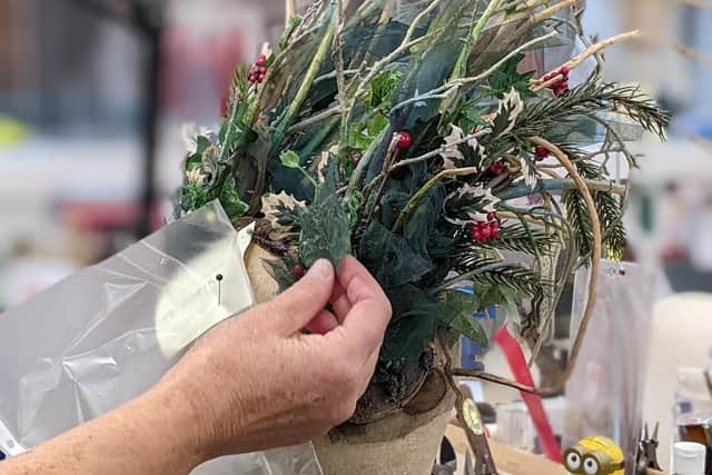 A headdress for the Ghost of Christmas Present is being made. Using hazel from a costumier's allotment it will also be decorated with a host of specially-made fabric ivy leaves