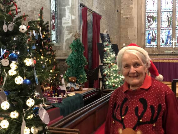Festival organiser Chris Wells is pictured in All Saints Church, Middleton Cheney with the decorated trees