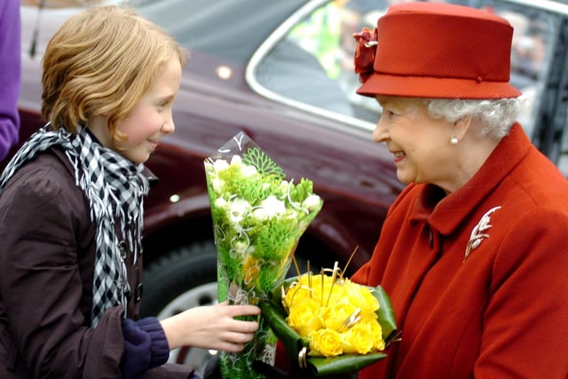 The Queen meets people on the walkabout outside the town hall and is given a posy by a supporter.