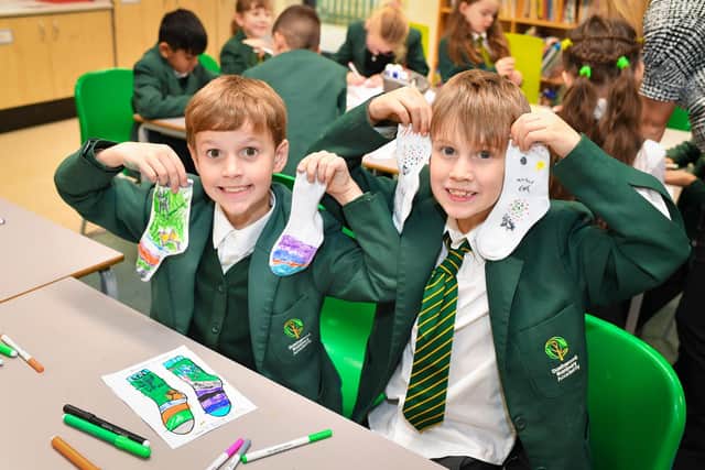 Pupils at Dashwood Banbury Academy showcasing their sock designs for Odd Socks Day.