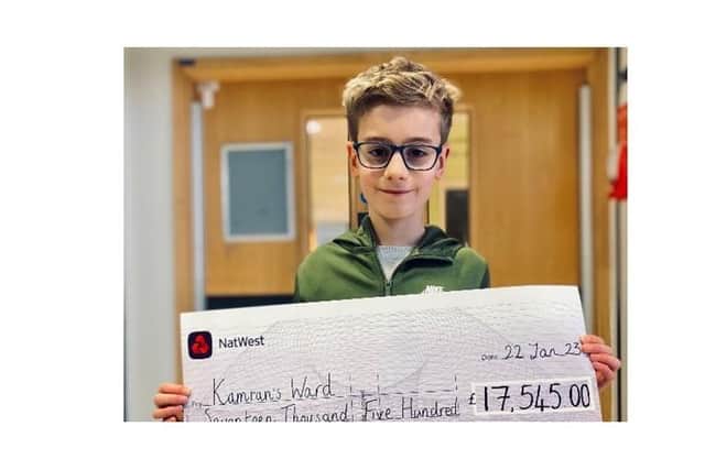 Finn Haggar with the huge cheque the family handed over to the Oxford University Hospitals charity