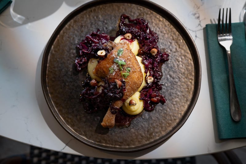 Confit duck leg, served with pommes puree,  balsamic braised red cabbage and topped with  a hazelnut crumb
