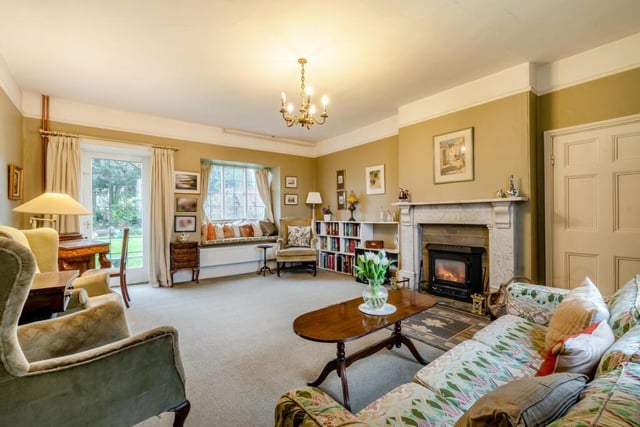 The drawing room features an open fireplace with wood burning stove, hearth and fender with a marble surround.