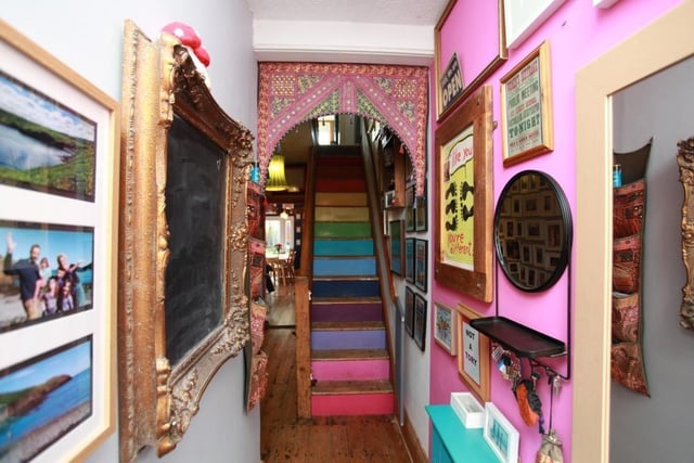 The colourful entrance corridor contains stripped floorboards and a radiator.
