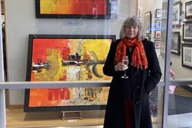 Renee Mascari in front of one of her paintings at the Aura Fine Art Gallery.
