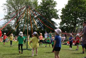 Pupils of Cropredy Primary School performing traditional Maypole dances in the sunshine.