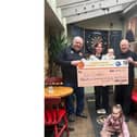 Clive and Ronnie from the Banbury United Community Lottery present lottery winner Eve Cambell and her family with a cheque.