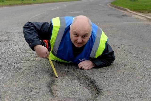 Mark Morrell, aka Mr Pothole, measuring the depth of a pothole