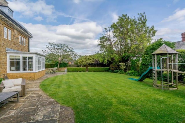 The back garden has a lawn with mature borders and a sun terrace.