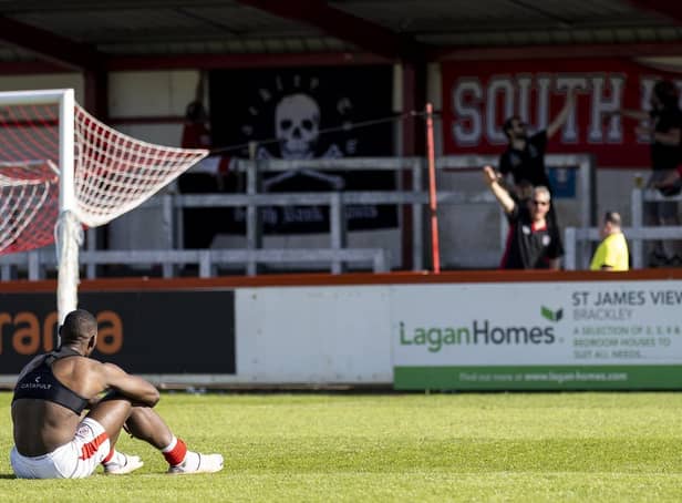Lee Ndlovu sits on the St James Park pitch after Brackley Town's play-off semi-final defeat to York City. Pictures by Glenn Alcock