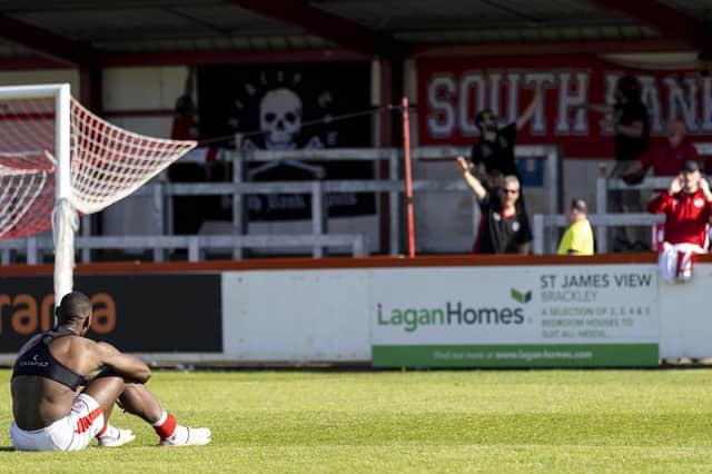 Lee Ndlovu sits on the St James Park pitch after Brackley Town's play-off semi-final defeat to York City. Pictures by Glenn Alcock