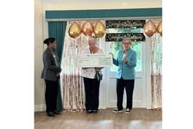 Denise Turner from the Ardley and Fewcott Gardening Club receiving the cheque from staff at the Chacombe Park care home.