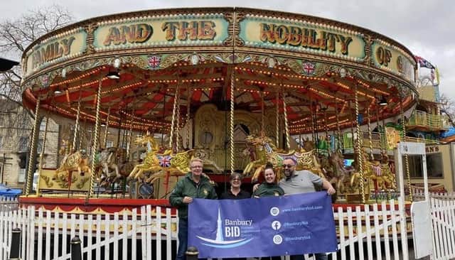 Members of Banbury BID pose in front of the carousel.