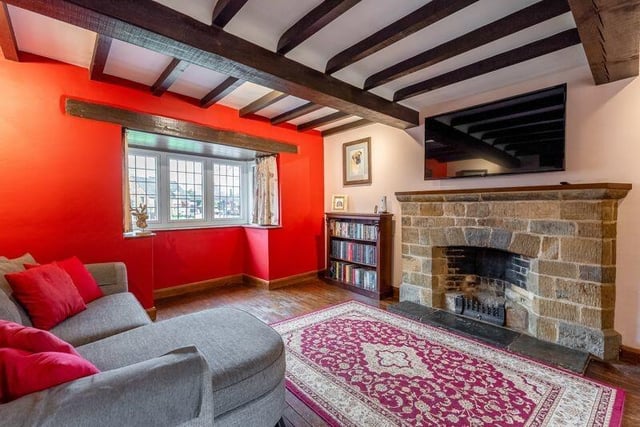 The living room has a central fireplace, beamed ceilings, a cast iron radiator and wooden block flooring.