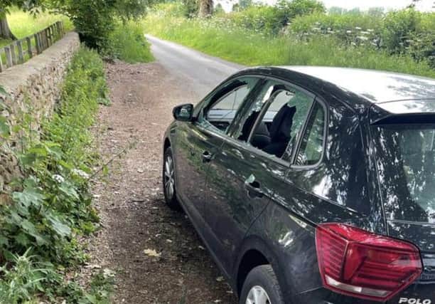 A car in the small lay-by at the gate of Broughton Castle with a smashed window after a break in