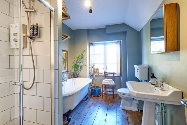The bathroom features the original elm boards and wooden shutters.