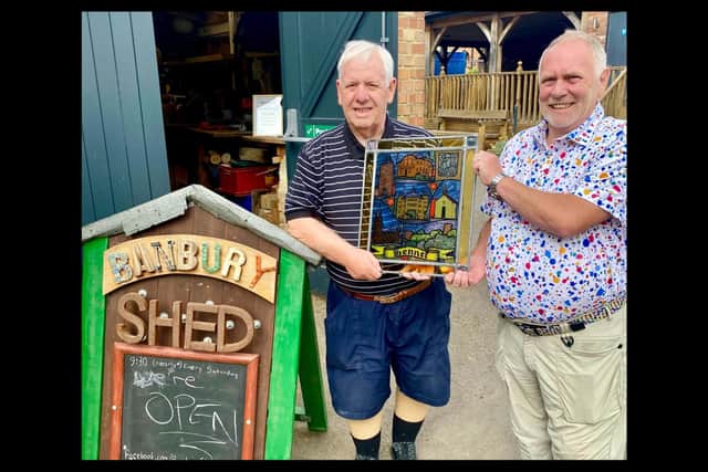 John Donaldson, chairman of the Banbury and District Twinning Association Chairman alongside Scotty of the Banbury shed group with the glass art piece. Credit Banburyshire Info