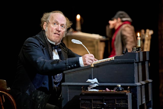 Scrooge (Ade Edmondson) in his counting house