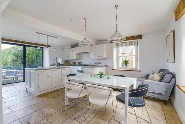 The kitchen has flagstone flooring and bi-fold doors opening to the outside eating terrace.
