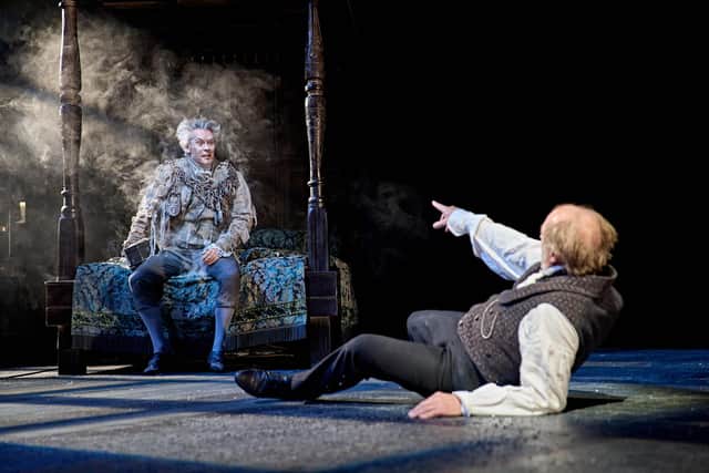 Scrooge (Ade Edmondson) is taken by surprise as the Ghost of Jacob Marley (Giles Taylor) appears through the bed he was sleeping in
