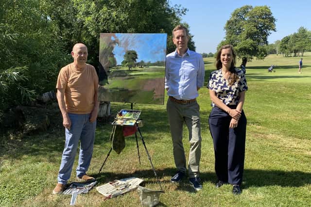 Artist Mark Owen, painting on the golf course at Feldon Valley, with resort managing director David King and hotel manager Melanie Genz.