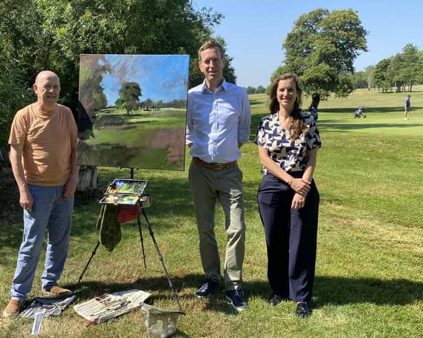 Artist Mark Owen, painting on the golf course at Feldon Valley, with resort managing director David King and hotel manager Melanie Genz.