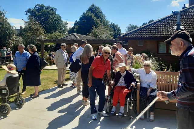 Residents, families, friends and members of the local community enjoying the Lake House garden.