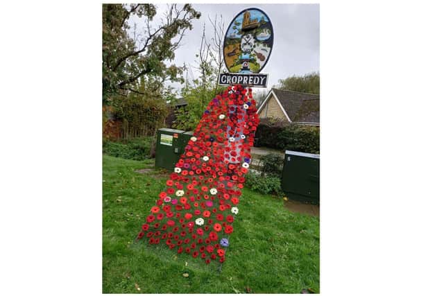The Cropredy Women’s Institute have knitted, crocheted and stitched a large cascade of poppies to hang from the village sign.