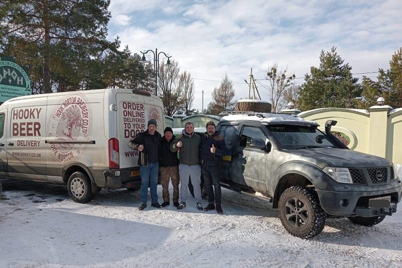 Viktor, Paul, Matthew, and Volodya are pictured together next to James Clarke's Hook Norton Brewery van.