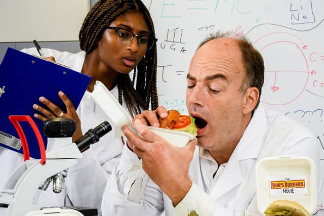 Professor Spence tests the burger - with gherkins
