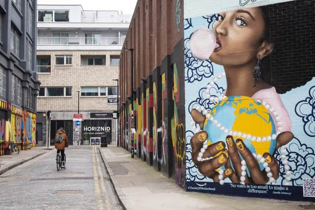 A mural by artist, Rosie Woods of Jonelle Awomoyi is unveiled as part of #TheArtOfMotherhood series by Amazon Handmade marking MotherÕs Day, to celebrate her efforts in caring for her local community during the pandemic, at the Shoreditch Panel in London. PA Photo. Issue date: Monday March 8, 2021. The campaign features three hand-painted murals of women, painted by women and can be found in London, Cardiff and Glasgow. Jonelle was selected to receive the tribute due to her tireless campaigning for youth issues in Croydon, London and beyond. Photo credit should read: Matt Alexander/PA Wire
