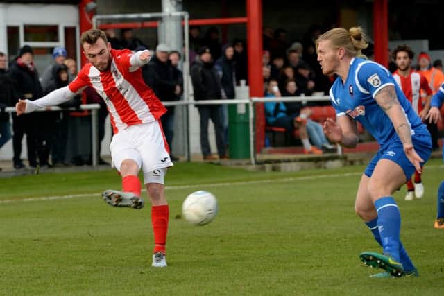 Brackley Town's Shane Byrne gets a cross despite the attentions of Salford City's Garl Pieregianni