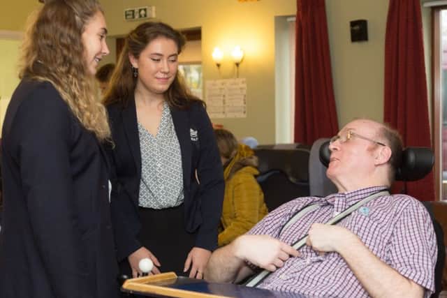 Oxford University women's rugby team captain Sophie Behan and Hazel Ellender chat to a resident at Agnes Court. Photo: Keith Barnes/Leonard Cheshire Disability NNL-171127-100045001